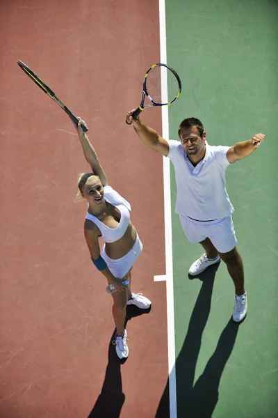 Joyeux jeune couple jouer au tennis jeu de plein air — Photo