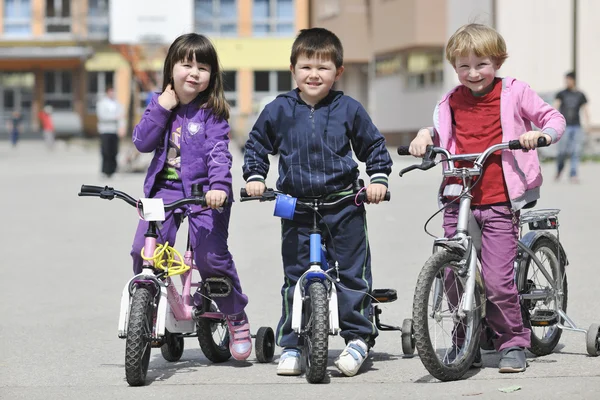 Grupo de crianças felizes aprendendo a dirigir bicicleta — Fotografia de Stock