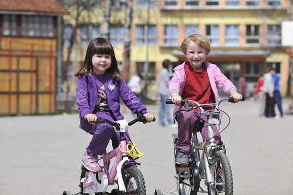 Heureux groupe d'enfants apprenant à conduire un vélo — Photo