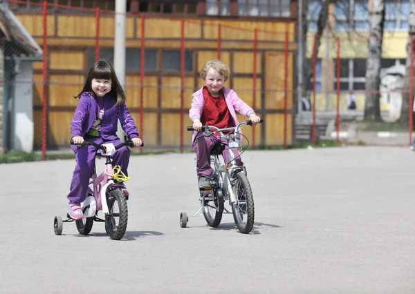 Heureux groupe d'enfants apprenant à conduire un vélo — Photo