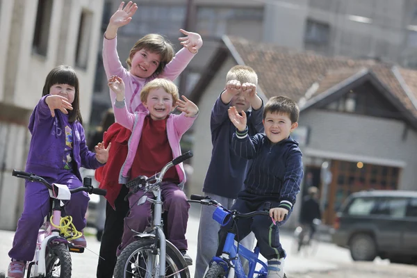 Щаслива дитяча група вчиться водити велосипед — стокове фото