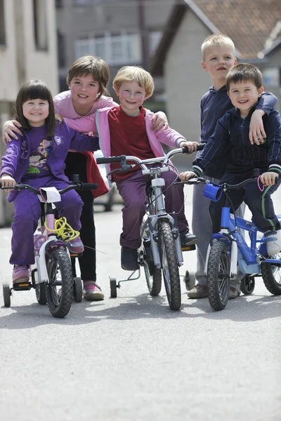 Glückliche Kindergruppe lernt Fahrradfahren — Stockfoto