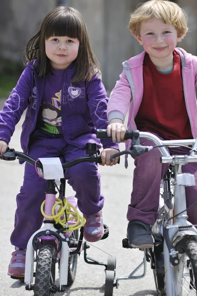 Щаслива дитяча група вчиться водити велосипед — стокове фото