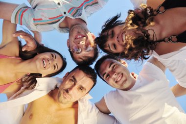 Happy family playing with dog on beach clipart