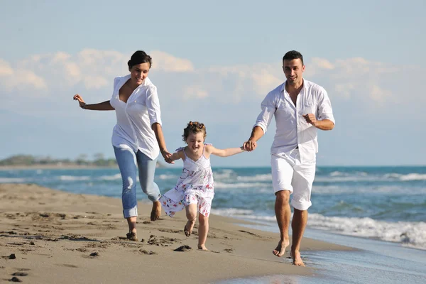 Щаслива молода сім'я розважається на пляжі — стокове фото