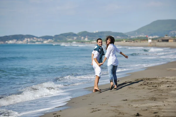 Onnellinen nuori pari pitää hauskaa kauniilla rannalla — kuvapankkivalokuva