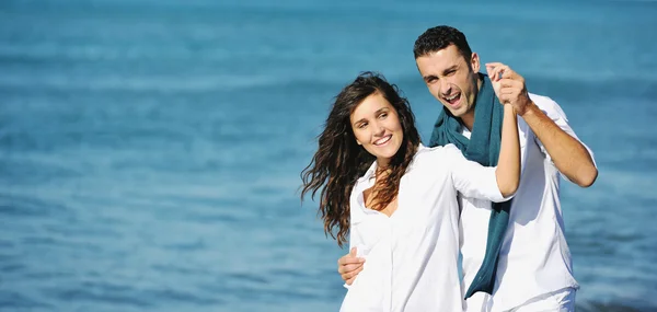 Heureux jeune couple avoir du plaisir à la belle plage — Photo