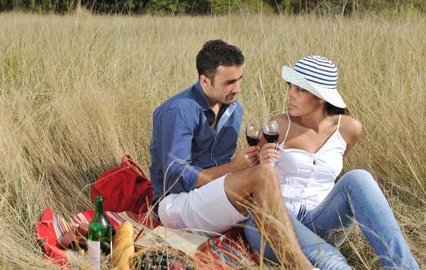 Szczęśliwa para korzystających wiejski piknik w długiej trawie — Zdjęcie stockowe