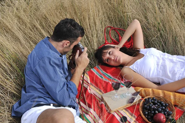 Casal feliz desfrutando de piquenique rural em grama longa — Fotografia de Stock