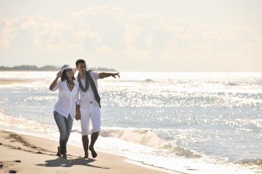 Mutlu genç çift güzel kumsalda eğleniyor.