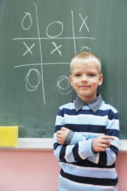 Birinci sınıf matematik sınıfındaki mutlu genç çocuk.
