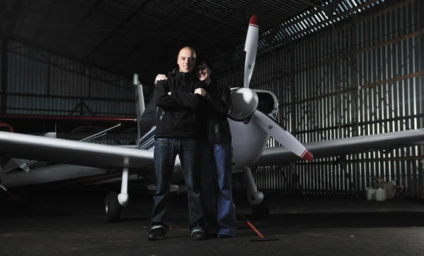 Happy young couple posing in front of private airplane — Stock Photo, Image