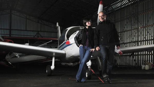 Feliz joven pareja posando frente a un avión privado —  Fotos de Stock