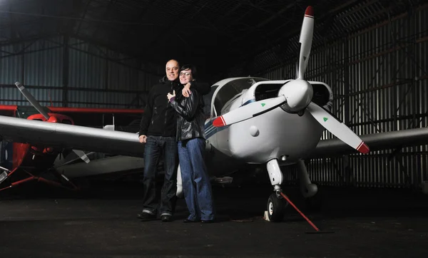 Feliz jovem casal posando na frente de avião privado — Fotografia de Stock