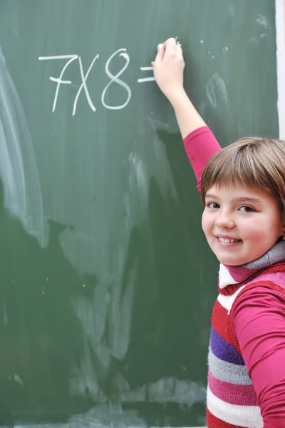 Счастливая школьница на уроках математики — стоковое фото
