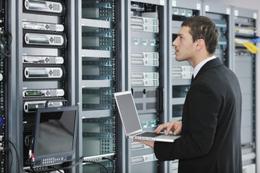  Young handsome business man it engineer in datacenter server room clipart