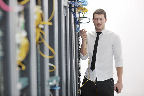 Joven hombre de negocios guapo ingeniero en la sala de servidores del centro de datos — Foto de Stock