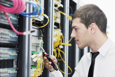 Young it engeneer in datacenter server room clipart