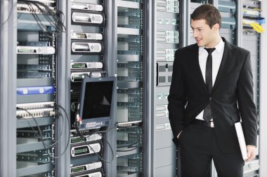 Young it engeneer in datacenter server room clipart