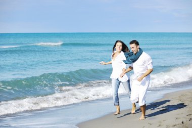 Mutlu genç çift güzel kumsalda eğleniyor.