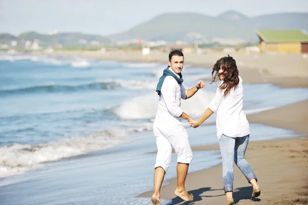快乐对年轻夫妇在白色的衣服有浪漫休闲乐趣在和美丽的海滩上度假 — 图库照片