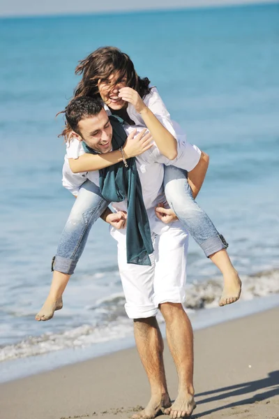 幸せな若いカップルは美しいビーチで楽しんでいます ストック画像