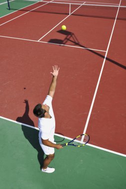 genç adam play Tenis açık portakal tenis kortunda sabah