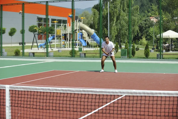 Νεαρός άνδρας παίζουν τένις υπαίθρια — Φωτογραφία Αρχείου