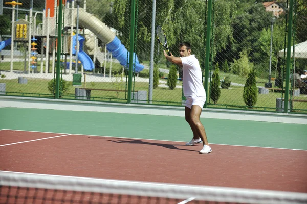 Joven jugar al tenis al aire libre — Foto de Stock