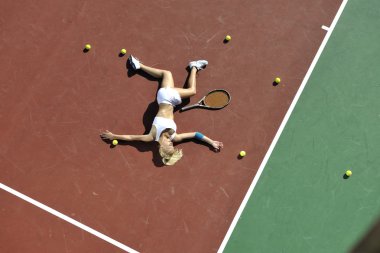 genç kadın oyun Tenis açık portakal Tenis alanında erken sabah saat yerleştirmek.