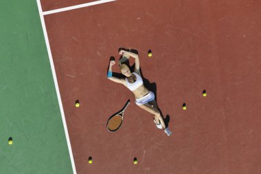 genç kadın oyun Tenis açık portakal Tenis alanında erken sabah saat yerleştirmek.