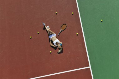 genç kadın oyun Tenis açık portakal Tenis alanında erken sabah saat yerleştirmek.