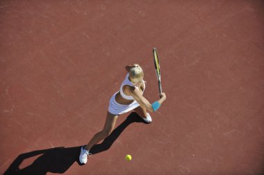 genç kadın oyun Tenis açık portakal Tenis alanında erken sabah saat yerleştirmek.