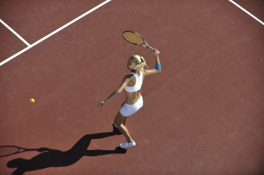 genç kadın oyun Tenis açık portakal Tenis alanında erken sabah saat yerleştirmek.