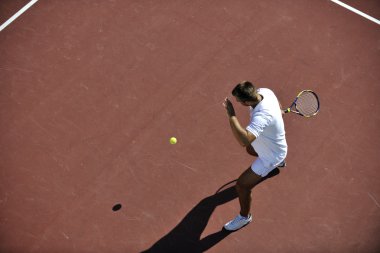 Genç adam tenis oynuyor