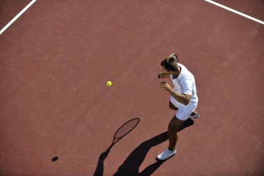 Genç adam tenis oynuyor