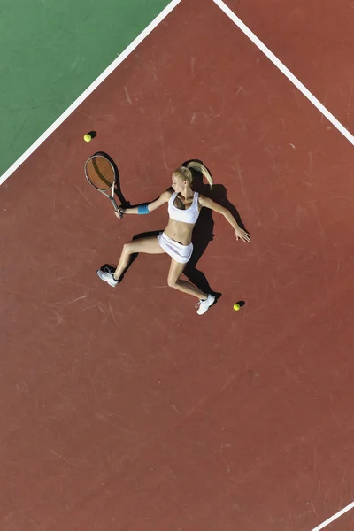 Молодая женщина играет в теннис на открытом воздухе — стоковое фото