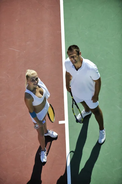 Joyeux jeune couple jouer au tennis jeu de plein air — Photo