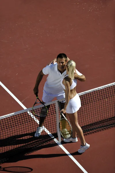 Lyckliga unga paret spela tennisspel utomhus — Stockfoto