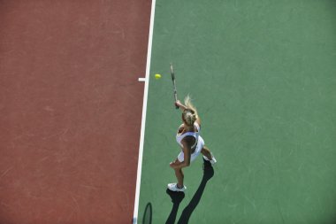 genç kadın oyun Tenis açık portakal Tenis alanında erken sabah saat yerleştirmek.