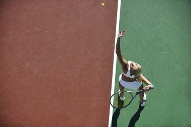 genç kadın oyun Tenis açık portakal Tenis alanında erken sabah saat yerleştirmek.