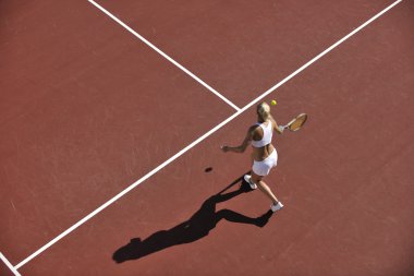 genç kadın oyun Tenis açık portakal Tenis alanında erken sabah saat yerleştirmek.