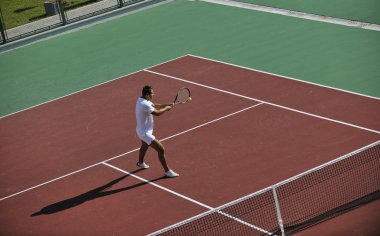 genç kadın oyun Tenis açık portakal Tenis alanında erken sabah saat yerleştirmek.