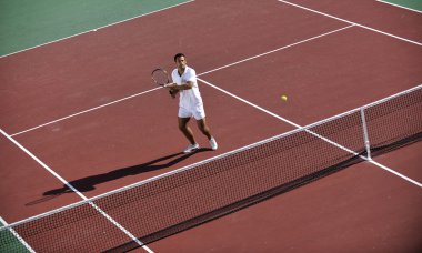 Genç adam tenis oynuyor