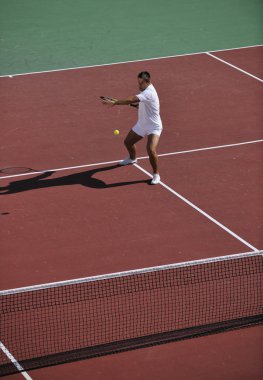 Genç adam tenis oynuyor