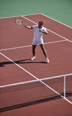 Genç adam tenis oynuyor