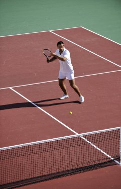 Genç adam tenis oynuyor