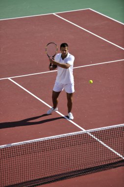 Genç adam tenis oynuyor