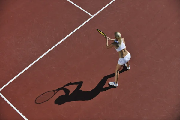 Молода жінка грає в теніс на відкритому повітрі — стокове фото