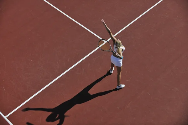 Jeune femme jouer au tennis en plein air — Photo